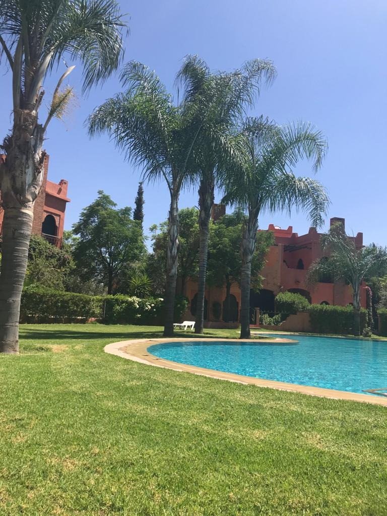 Belle Villa de 3 chambres bien meublée à louer avec cheminée terrasse , piscine et beau jardin privatifs dans une résidence avec piscine collective, terrain de tennis, salle de sport et beaux espaces verts à 5 km du centre de Marrakech sur la route de Fès